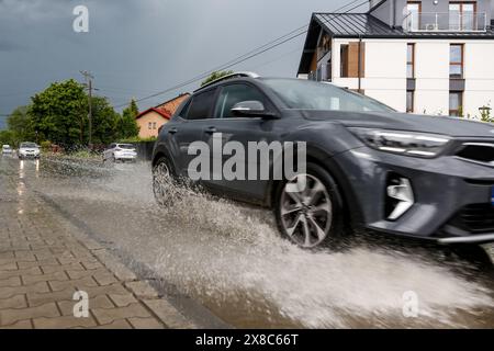 Krakau, Polen, 24. Mai 2024. Ein Auto fährt durch eine tiefe Pfütze auf einer Straße in einem Wohngebiet, während ein Sturm mit starkem Wind und Hagel durch Krakau zieht. Quelle: Dominika Zarzycka/Alamy Live News. Stockfoto