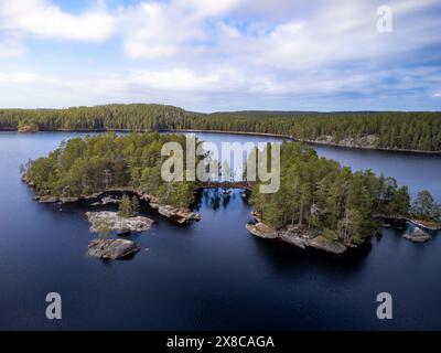 Luftaufnahme eines ruhigen Sees mit kleinen, von Bäumen bedeckten Inseln, mit ruhigem blauem Wasser und üppiger grüner Umgebung. Stockfoto