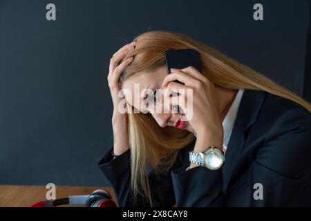 Gestresste Geschäftsfrau, die im Büro telefoniert Stockfoto