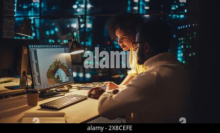 Junger Kreativdirektor und Designer spricht über Arbeit, nimmt Änderungen am Unternehmensprojekt am Computer in der Architekturagentur in Loft Office vor. Zwei Stilvolle Mitarbeiter Diskutieren Landscape Project. Stockfoto