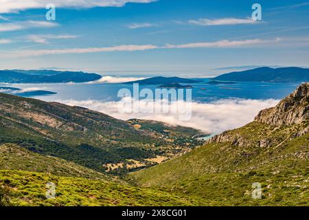 Morgens niedrige Wolken, Inseln am Petalioi Golf an der Ägäis, in der Nähe des Dorfes Marmari am Meer, Blick von der Autobahn nach Karystos, Evia Island, Griechenland Stockfoto