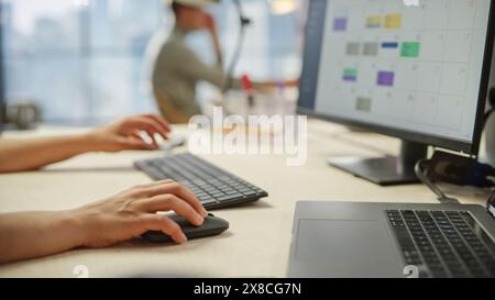 Nahaufnahme von Frauenhänden, die an Tastatur und Monitor arbeiten. Die Hände der jungen Frau bewegen die Computermaus und tippen. Weibliche Vertriebsleiterin, die einen Zeitmanagementplan entwickelt Stockfoto