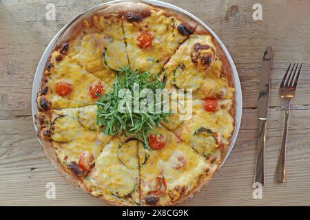 Pizza mit Rucola, Zucchini, Mini-Tomaten, Käse und Lachs Stockfoto