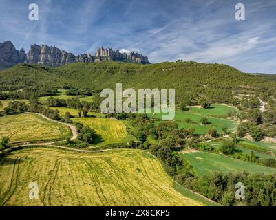 Aus der Vogelperspektive auf den Berg Montserrat von den Feldern rund um Sant Esteve de Marganell im Frühling (Bages, Barcelona, Katalonien, Spanien) Stockfoto