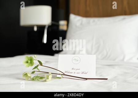 Hintergrundbild der Begrüßungsnotiz mit zartem Blumendekor auf dem Bett im luxuriösen Kopierraum des Hotelzimmers Stockfoto