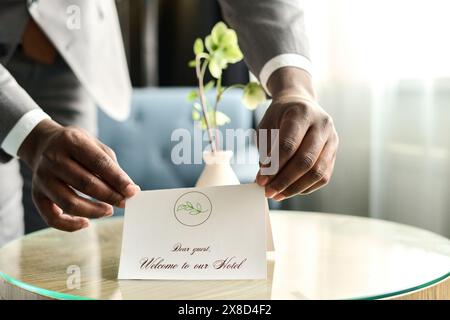Nahaufnahme der männlichen Hände sorgfältig arrangieren Begrüßungsnotiz für Gäste im Kopierbereich des Luxushotels Stockfoto