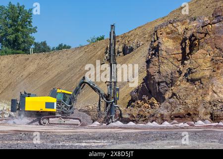 Die vertikale Bohranlage im Steinbruch. Bohrtraktor, der in der Mine arbeitet. Bergbau Steinbruch, Mine. Ausrüstung für den Schwerbergbau. Stockfoto