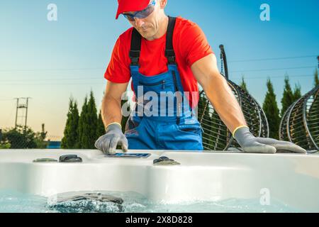 Der Arbeiter schrubbt und reinigt einen Whirlpool im Hinterhof. Stockfoto