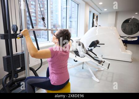 Reife Frau in Sportbekleidung, die im Fitnessstudio Sport treibt Stockfoto