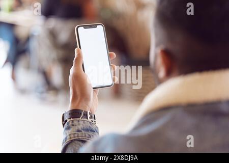 Mann-, Rücken- und Smartphone-Bildschirm im Café, Mock-Up und Nachrichtenbenachrichtigung oder entspannen Sie sich mit der technischen mobilen App. Durchsuchen, E-Mails senden und soziale Medien oder Stockfoto