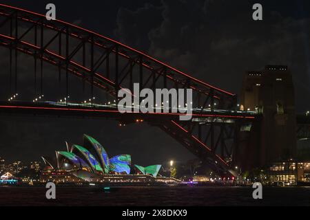Sydney, Australien. Mai 2024. Die Beleuchtung beleuchtet die Sydney Harbour Bridge (im Vordergrund) und Kunstwerke werden am ersten Tag von Vivid Sydney auf die Segel des Sydney Opera House (im Hintergrund) projiziert. Vivid Sydney ist eine jährliche Veranstaltung, bei der Kreativität, Innovation und Technologie gefeiert werden. Die Veranstaltung wird durch Lichtskulpturen, multimediale interaktive Arbeiten und Lichtprojektionen auf großen Gebäuden rund um Sydney hervorgehoben. Die diesjährige Feier dauert ab dem 24.. Bis 15. Mai. Juni 2024. (Foto: Luis Veniegra/SOPA Images/SIPA USA) Credit: SIPA USA/Alamy Live News Stockfoto