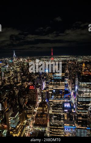 Manhattans nächtliche Skyline aus einer gewagten Perspektive von oben. Hoch aufragende Riesen durchdringen die Wolken und bieten einen einzigartigen Aussichtspunkt für Reisen. Stockfoto