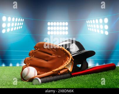 Baseballschläger, Handschuh, Helm und Ball auf dem Gras im Stadion Stockfoto