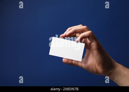 Mann mit leerer Visitenkarte auf blauem Hintergrund, Nahaufnahme. Modell für Design Stockfoto