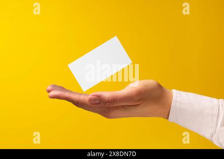 Frau mit leerer Visitenkarte auf gelbem Hintergrund, Nahaufnahme. Modell für Design Stockfoto