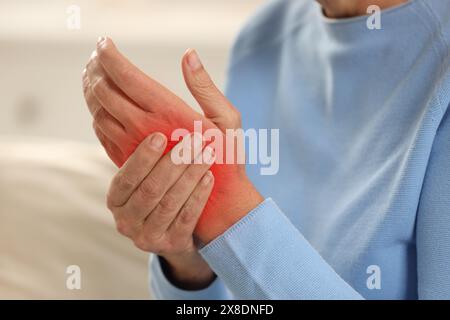 Frau mit Schmerzen im Handgelenk drinnen, Nahaufnahme Stockfoto