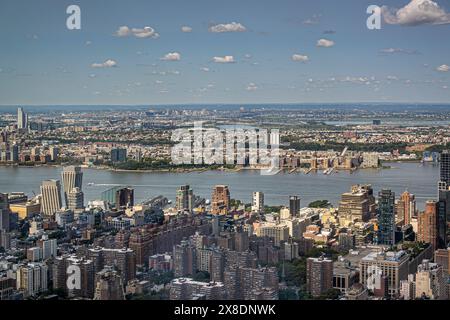 New York, NY, USA - 2. August 2023: Stadtbild auf beiden Seiten des Hudson River nördlich des Pier 57 unter blauer Wolkenlandschaft, vom Empire State Building aus gesehen Stockfoto