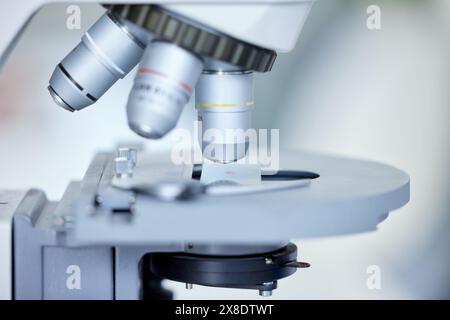 Mikroskop, Nahlabor und Wissenschaft mit DNA für Bluttests, Haar- oder Gewebeproben. Leer, Biologie und Ausrüstung mit Forensik für Genetik Stockfoto