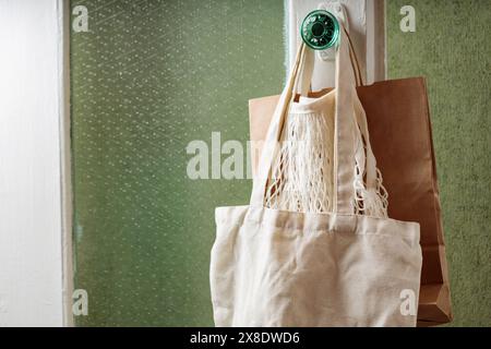 Taschen aus Baumwolle, Netzgewebe und Papier, die am Türgriff hängen, Zero Waste Lifestyle-Konzept Stockfoto