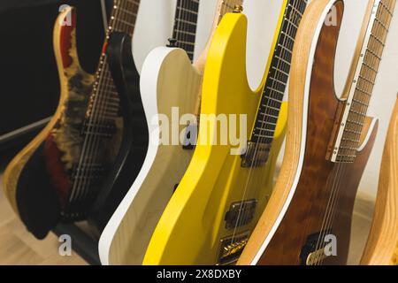 Verschiedene E-Gitarren, Bassgitarren, akustische und klassische Gitarren am Stand, Probenkonzept. Hochwertige Fotos Stockfoto