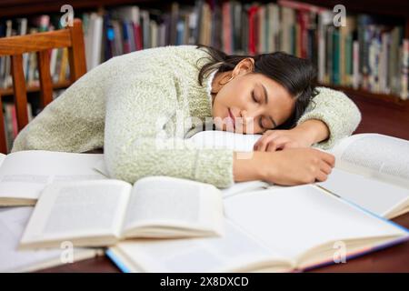 Schüler, schlafende Frau und Bibliotheksbuch mit Studium, Prüfung und Kursforschung für Projekt in der Schule. Universität, müde und Notizen mit Lernen Stockfoto