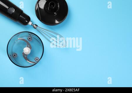 Stabmixer-Kit. Schneebesen, Deckel, Schüssel und Schüssel Zerkleinerer auf hellblauem Hintergrund, flach gelegt. Leerzeichen für Text Stockfoto