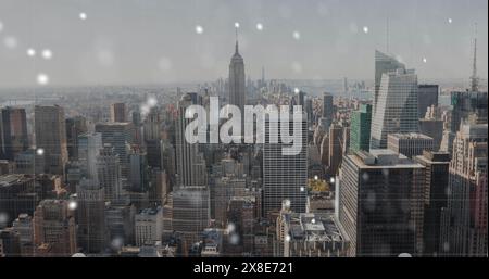 Schneeflocken fallen sanft über die geschäftige Skyline der Stadt Stockfoto