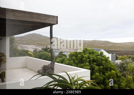 Im Freien, Balkon mit Blick auf üppiges Grün und ferne Hügel Stockfoto