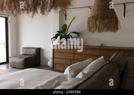 Zu Hause, rustikale Holzmöbel und große Pflanze dominieren ein Schlafzimmer Stockfoto