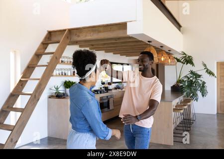 Ein vielseitiges Paar tanzt zu Hause in einer modernen Küche Stockfoto