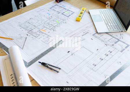 Architektonische Baupläne und Zeichenwerkzeuge befinden sich auf Holztisch Stockfoto