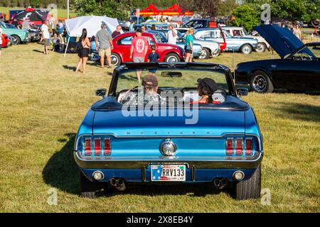 Ein Paar in einem blauen Ford Mustang Cabrio aus dem Jahr 1967 kommt auf der Autoshow im Riverside Gardens Park in Leo-Cedarville, Indiana, USA. Stockfoto