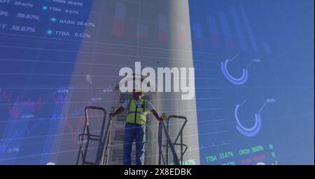 Kaukasischer männlicher Ingenieur mit Sicherheitsausrüstung und Tablet mit Daten-Overlays Stockfoto