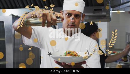 Der kaukasische Koch mittleren Alters präsentiert Pasta-Teller und arbeitet in einer belebten Küche Stockfoto