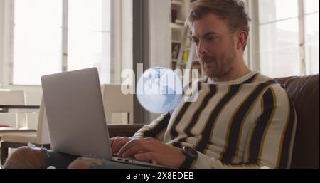 Bild eines Globus, der sich mit einem Laptop über einem kaukasier dreht Stockfoto