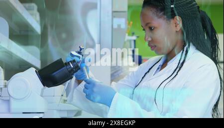 Bild der medizinischen Schnittstellen über afroamerikanische Wissenschaftlerin, die Proben aus dem Reagenzglas entnimmt Stockfoto