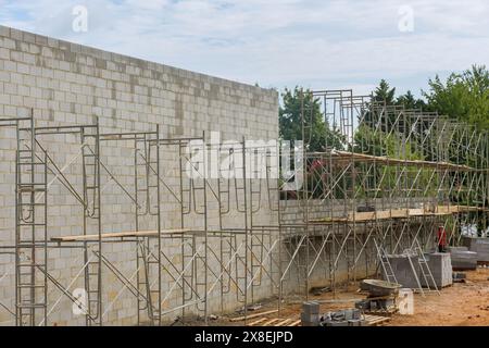 Auf Gerüsten baut Maurer Betonwände aus Betonblöcken Stockfoto