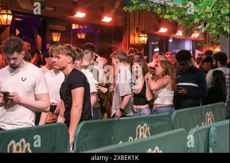 Broad Street, Birmingham, 25. Mai 2024 - die Revellers besuchten die berüchtigte Broad Street in Birmingham am Freitagabend, um die Feiertagsfeier zu beginnen. Die Partygäste haben Rosies und Heidis Nachtklubs in den Streifen gepackt. Gruppen von Freunden posierten für Fotos, während andere ihren Freunden Huckepacks die Straße hinunter von Club zu Club gaben. Die West Midlands Police war ebenfalls außer Kraft. Eine Gruppe von Männern wurde von zwei Polizisten befragt, nachdem sie mit einem großen Kanister Stickstoffoxid, auch bekannt als „Hippie Crack“, entdeckt wurden, das jetzt eine Droge der Klasse C ist. Sanitäter wurden auch in den Nachtleben-Bereich nach hinten gerufen Stockfoto