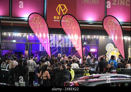 Broad Street, Birmingham, 25. Mai 2024 - die Revellers besuchten die berüchtigte Broad Street in Birmingham am Freitagabend, um die Feiertagsfeier zu beginnen. Die Partygäste haben Rosies und Heidis Nachtklubs in den Streifen gepackt. Gruppen von Freunden posierten für Fotos, während andere ihren Freunden Huckepacks die Straße hinunter von Club zu Club gaben. Die West Midlands Police war ebenfalls außer Kraft. Eine Gruppe von Männern wurde von zwei Polizisten befragt, nachdem sie mit einem großen Kanister Stickstoffoxid, auch bekannt als „Hippie Crack“, entdeckt wurden, das jetzt eine Droge der Klasse C ist. Sanitäter wurden auch in den Nachtleben-Bereich nach hinten gerufen Stockfoto