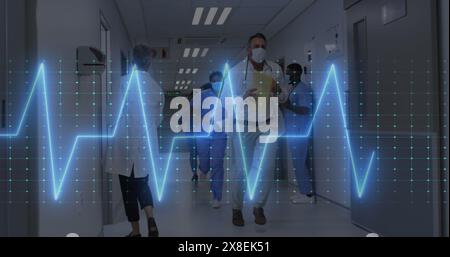Bild des Herzfrequenzmessers über verschiedene Ärzte und Heilkräfte, die im Krankenhauskorridor arbeiten Stockfoto