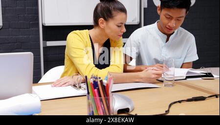 Eine vielfältige Gruppe junger Studenten, die gemeinsam in modernen Klassenzimmern studieren Stockfoto