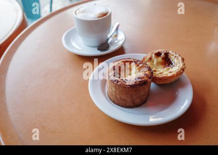 Nahaufnahme zweier portugiesischer Pudding-Torten, auch bekannt als Pastéis de Nata, serviert auf einem weißen Teller. Stockfoto