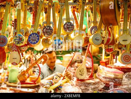 URUMQI, CHINA - 24. MAI 2024 - Ein Ladenbesitzer stellt Musikinstrumente für Besucher in einem Musikinstrumentengeschäft im Xinjiang International Grand ein Stockfoto