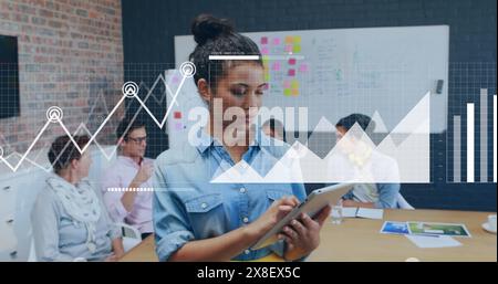 Bild der statistischen Datenverarbeitung über birassische Frau mit lächelndem digitalem Tablet im Büro Stockfoto