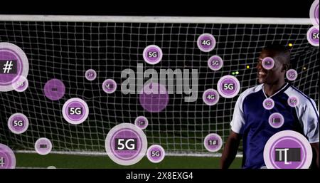 Bild: 5g-Text in Kreisen über afroamerikanischem Fußballspieler, der den Ball gegen den Torpfosten stoppt Stockfoto