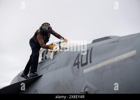 PHILIPPINE SEA (24. Mai 2024) der Flugzeugbaumechaniker Airman Jahkem Riggs aus Kanton, Ohio, reinigt das Cockpit einer F/A-18E Super Hornet, atta Stockfoto