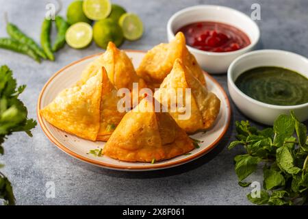 Selective Focus Samosa, mit Kartoffeln gefülltes Gebäck, knusprige, herzhafte, beliebte indische Snacks mit Tomaten- und Minzchutney-Tees. Stockfoto