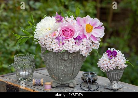 Blumenarrangement mit rosa Rose, Pfingstrosen-Blumen, Bratschenblüten, bellis, kolumbine und Beauty-Buschblüten in Vintage-Pflanzenvase Stockfoto