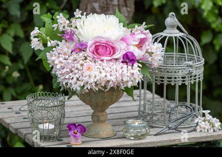 Blumenarrangement mit rosa Rose, Pfingstrosen-Blumen, Bratschenblüten, bellis, kolumbine und Beauty-Buschblüten in Vintage-Pflanzenvase Stockfoto