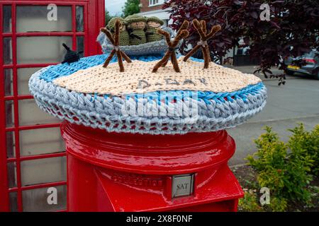 Eton Wick, Großbritannien. Mai 2024. Ein gestrickter und gehäkelter D-Day Anniversary Post Box Topper im Dorf Eton Wick, Windsor, Berkshire. Die Royal British Legion feiert am 5. Und 6. Juni 2024 das 80. D-D-Jubiläum in Großbritannien und der Normandie sowie Gemeindeveranstaltungen in ganz Großbritannien. Sie bitten Normandie-Veteranen, Familien der Gefallenen, Nachkommen der Normandie-Veteranen und die Öffentlichkeit, sich ihnen beim D-Tag 80 anzuschließen. Quelle: Maureen McLean/Alamy Live News Stockfoto